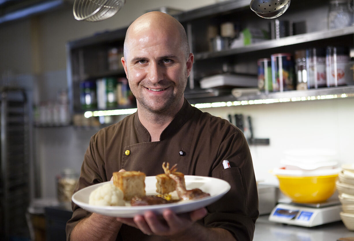 Küchenchef Philip Szemes mit einem Gericht in seiner Küche